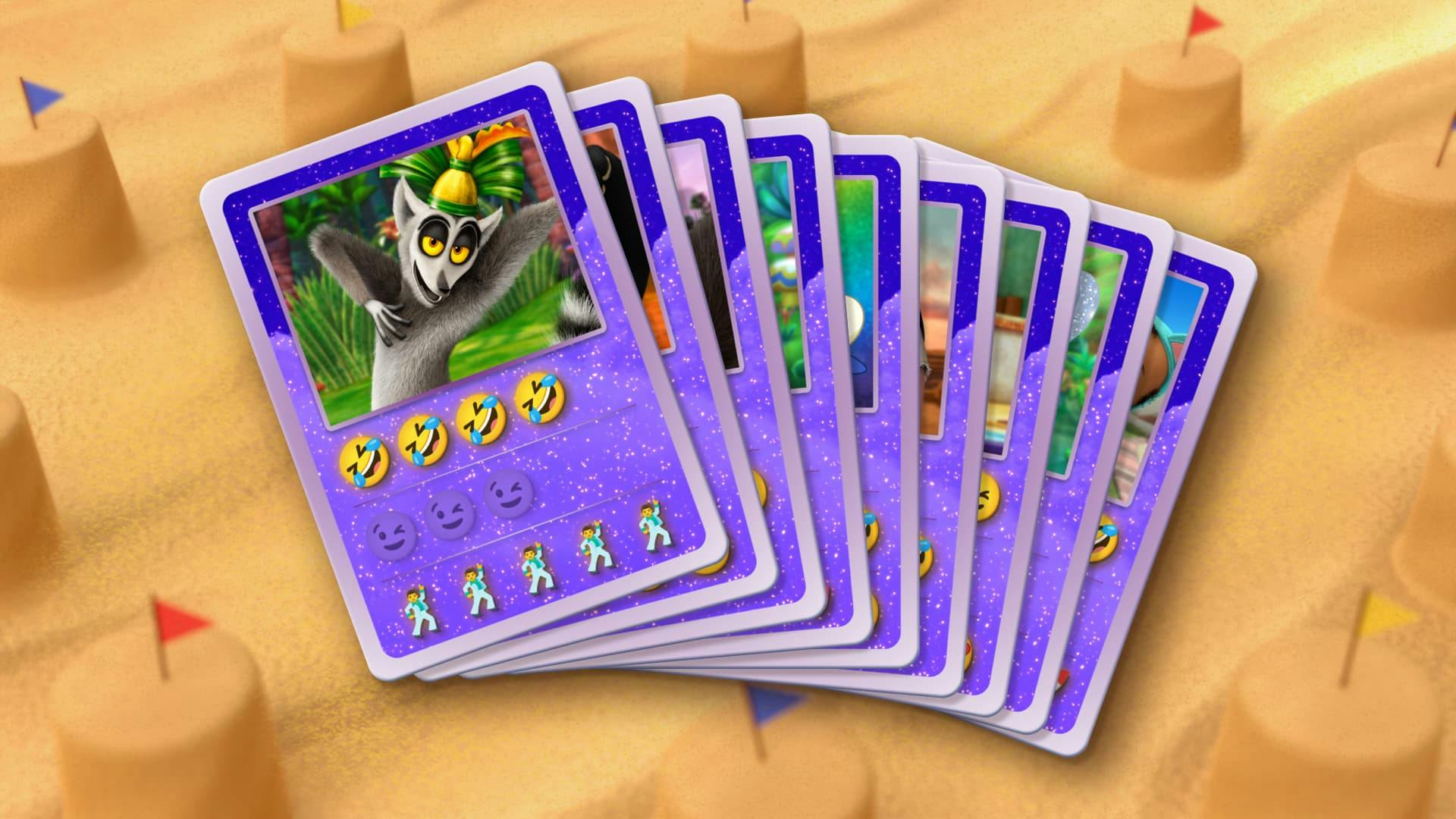 A deck of DreamWorks playing card are spread out with the faces of many popular DreamWorks characters on their covers. There is a beach with sandcastles in the background.