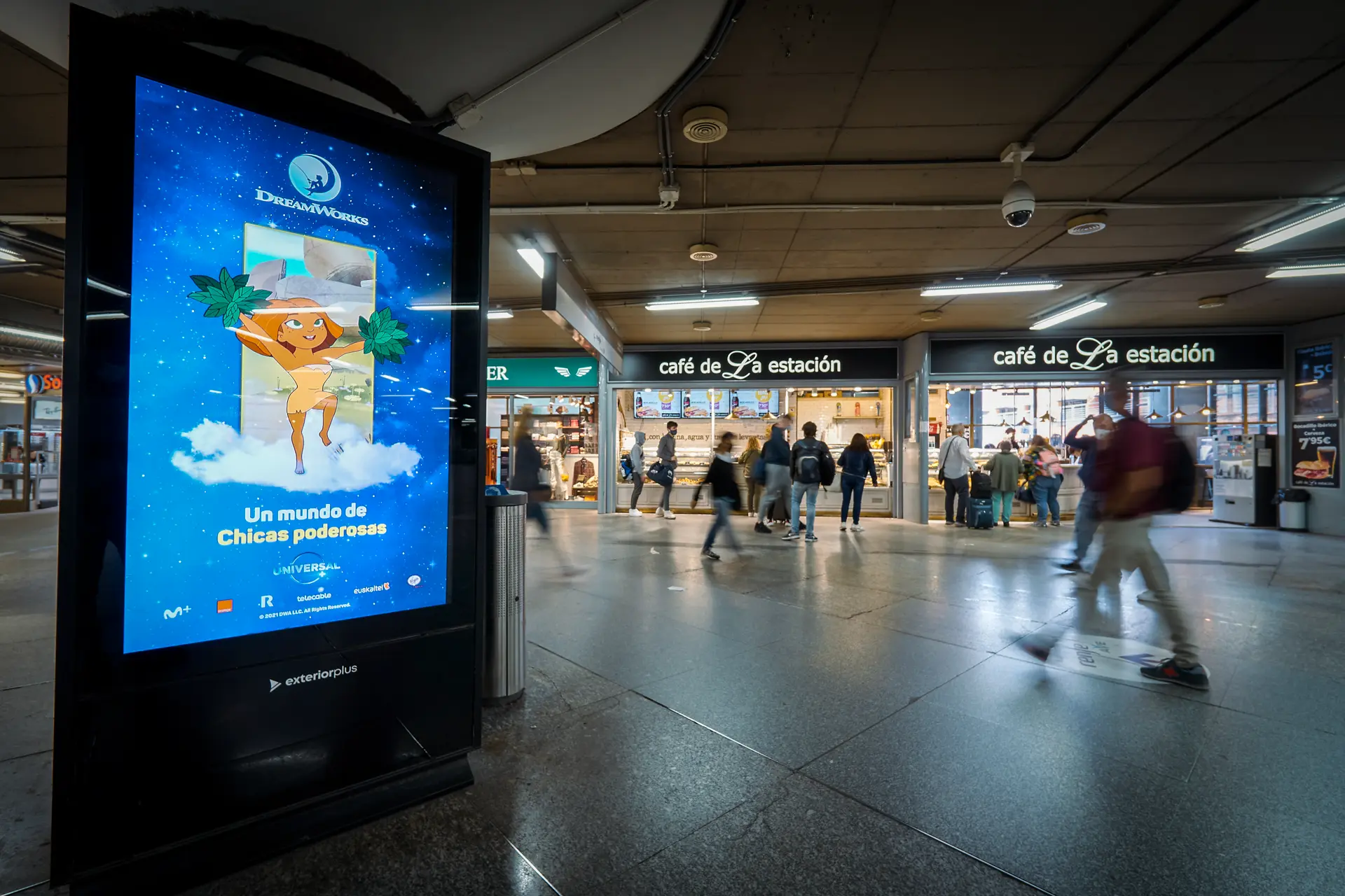 A DreamWorks TV poster on a digital screen in a Spanish railway station